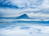 Un volcan semblant flotter au-dessus des nuages
